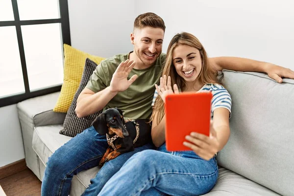 Junges Hispanisches Paar Telefoniert Touchpad Auf Dem Sofa Mit Hund — Stockfoto