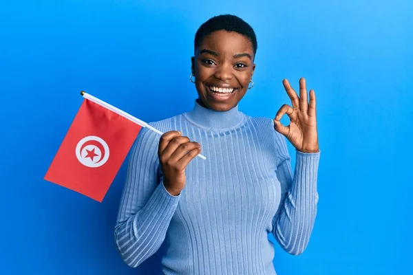 Νεαρή Αφροαμερικανή Γυναίκα Κρατώντας Σημαία Τουνισίας Κάνει Υπογράψει Δάχτυλα Χαμογελώντας — Φωτογραφία Αρχείου
