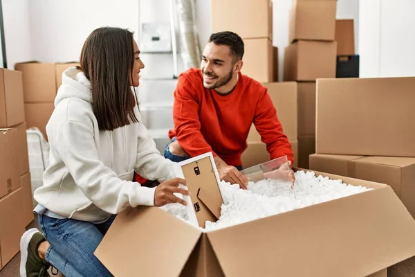 Young Latin Couple Smiling Happy Unboxing Cardboard Box New Home — Stock Photo, Image