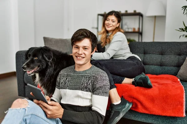 Jovem Casal Caucasiano Sorrindo Feliz Com Cão Usando Touchpad Casa — Fotografia de Stock