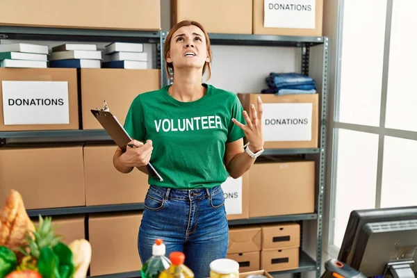 Young Brunette Woman Wearing Volunteer Shirt Donations Stand Crazy Mad — Stock Photo, Image