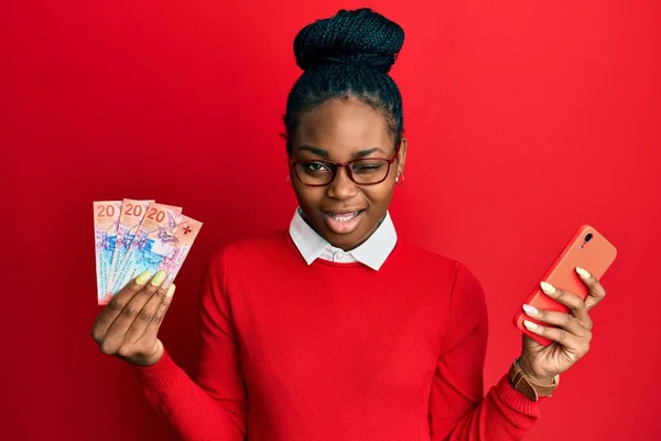 Молода Афроамериканська Жінка Допомогою Смартфона Тримає Смартфон Франк Банкноти Витріщаються — стокове фото