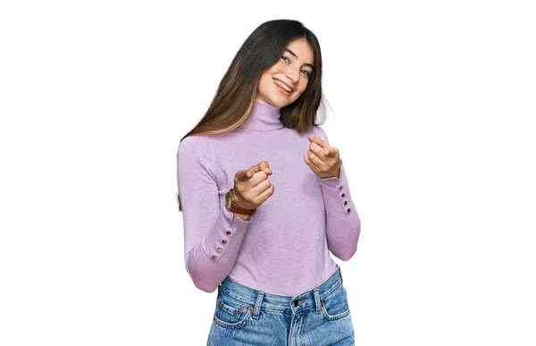 若い美しいティーンの女の子が幸せと面白い顔でカメラに指を指して亀のセーターを着ています 良いエネルギーと振動は — ストック写真