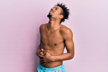 Sakallı, eli karnında mayo giyen Afro-Amerikalı genç bir adam. Çünkü mide bulantısı, acı verici bir hastalık kendini iyi hissetmiyor. Ağrı kavramı. 