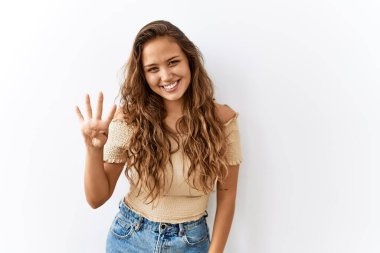 Güzel İspanyol kadın yalnız başına ayakta dikilirken arka planda dört numarayı gösterip işaret ederken kendinden emin ve mutlu bir şekilde gülümsüyor.. 