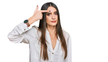 Gündelik beyaz tişört giyen genç ve güzel bir kadın alnındaki sivilceden mutsuz olduğunu gösteriyor. Siyah başlıklı çirkin bir enfeksiyon. sivilce ve deri problemi 