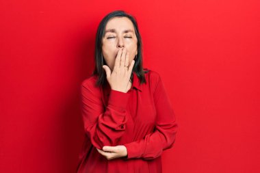 Orta yaşlı İspanyol kadın gündelik kıyafetler giyip ağzıyla ağzını kapatmaktan sıkılmış. Huzursuz ve uykulu.. 