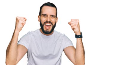 Sakallı, sıradan beyaz tişörtlü kızgın ve kızgın genç bir adam öfkeyle bağırırken kızgın ve öfkeli yumruklar sallıyor. öfke ve agresif konsept. 