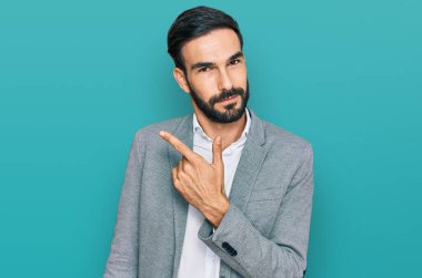 İş kıyafetleri giymiş genç İspanyol bir adam el ile işaret ederek reklamını yapıyor, ciddi ve sakin bir yüz ifadesi. 