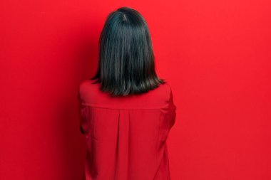 Orta yaşlı İspanyol kadın gündelik giysiler giyip arkasını dönüp kollarını kavuşturmuş bakıyor. 