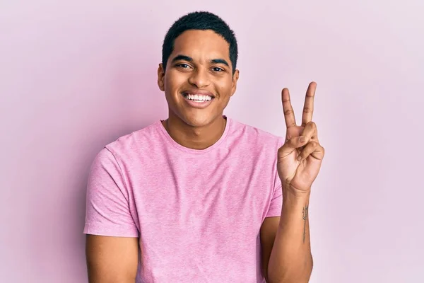 Mladý Pohledný Hispánec Neformální Růžové Tričko Usmívající Šťastnou Tváří Mrkající — Stock fotografie