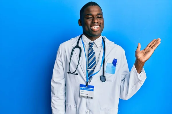 Jovem Afro Americano Vestindo Uniforme Médico Sorrindo Alegre Apresentando Apontando — Fotografia de Stock
