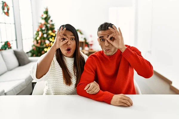 Jong Latijns Paar Zit Tafel Door Kerstboom Doen Gebaar Geschokt — Stockfoto