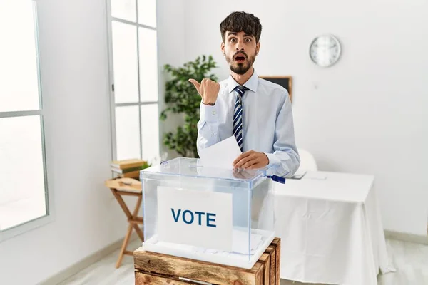 Hombre Hispano Con Barba Votando Poniendo Sobre Las Urnas Sorprendido —  Fotos de Stock
