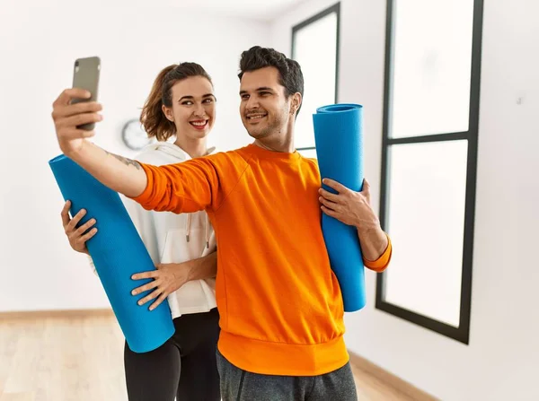 在体育中心 他的年轻夫妇拿着瑜伽垫 拿着智能手机自慰 惊慌失措 — 图库照片