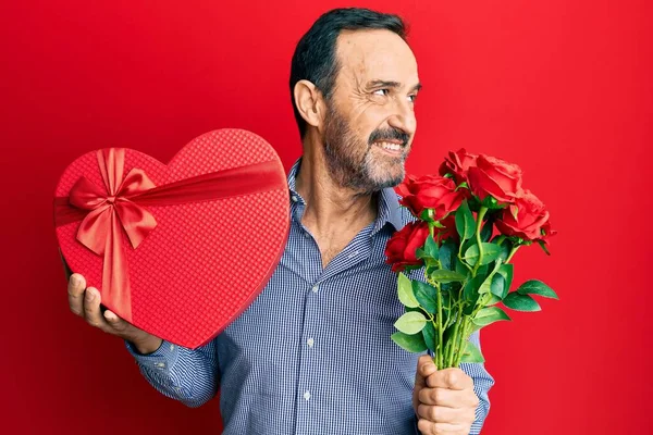 Middelbare Leeftijd Spaanse Man Met Valentijnsdag Geschenk Bloemen Glimlachend Kijken — Stockfoto