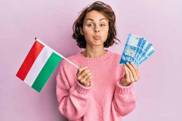 Mladá Brunetka Držící Maďarskou Vlajku Forintuje Bankovky Legračním Obličejem Nafouknutými — Stock fotografie