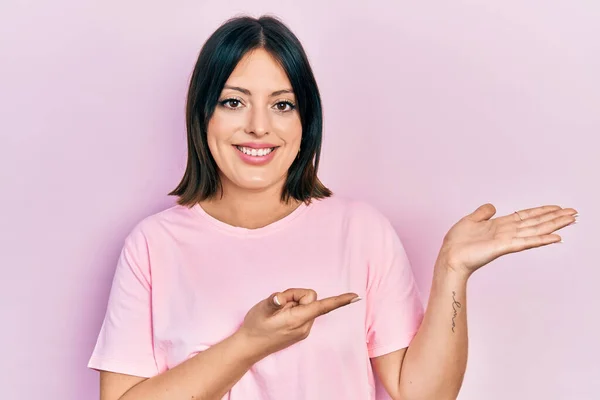 Jovem Hispânica Vestindo Camiseta Rosa Casual Espantada Sorrindo Para Câmera — Fotografia de Stock