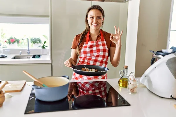 Mutfakta Önlük Giymiş Güzel Esmer Bir Kadın Parmaklarıyla Imza Atıyor — Stok fotoğraf