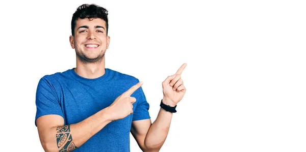 Mladý Hispánec Neformální Tričku Usmívá Dívá Kameru Ukazující Oběma Rukama — Stock fotografie