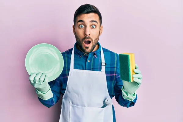 Молодий Іспаномовний Чоловік Одягнений Фартух Тримає Частіше Миття Посуду Боїться — стокове фото