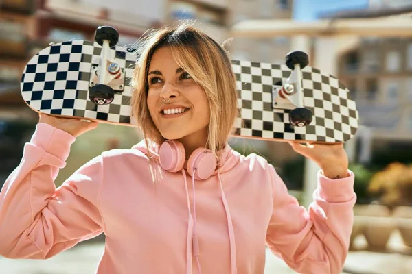 Jovem Menina Skatista Loira Sorrindo Feliz Segurando Patins Cidade — Fotografia de Stock