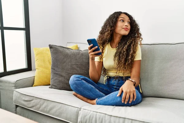 Evdeki Kanepede Oturan Güzel Spanyol Kadın Akıllı Telefon Kullanıyor Yüzünde — Stok fotoğraf