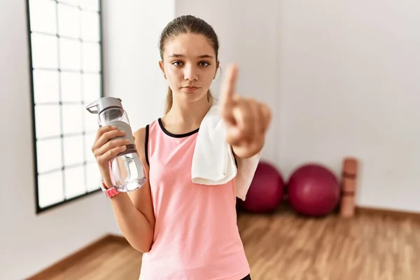身穿运动服的年轻的黑发少女拿着水瓶 手举着水瓶 满脸怒容 毫无表情 — 图库照片