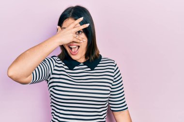 Gündelik kıyafetler giyen genç İspanyol kadın şok içinde yüzünü ve gözlerini kapayarak utanmış ifadesiyle parmaklarının arasından bakıyor.. 