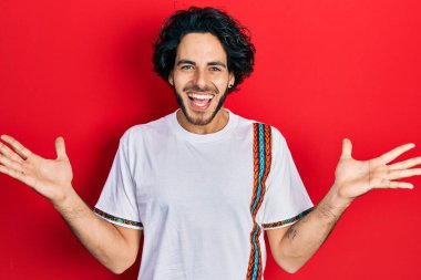 Yakışıklı, beyaz tişört giyen, mutlu bir gülümsemeyle zaferi kutlayan ve ellerini kaldırarak kazanan bir İspanyol. 