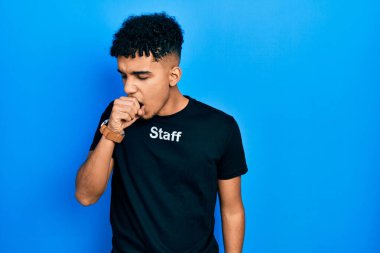 Asa tişörtü giyen genç Afro-Amerikan adam kendini kötü hissediyor ve soğuk algınlığı veya bronşitin belirtisi olarak öksürüyor. sağlık hizmeti kavramı. 