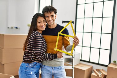 Genç latin çift gülümsüyor Mutlu ev projeleri yeni evinde tutuluyor.