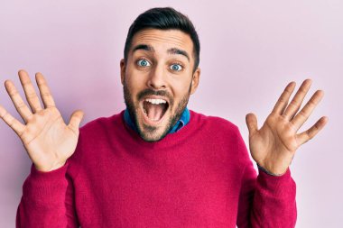 Sıradan kıyafetler giyen genç İspanyol adam çılgın ve başarıyı kollarını kaldırıp heyecanla haykırarak kutluyor. Kazanan konsept 