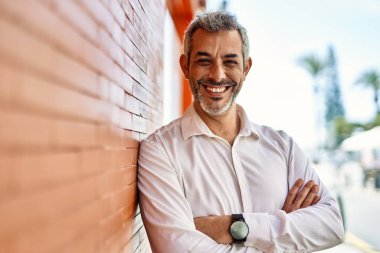 Orta yaşlı, kır saçlı, mutlu gülümseyen bir adam..