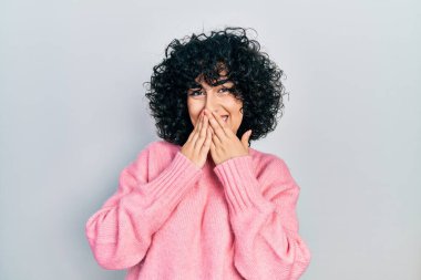 Orta Doğulu genç bir kadın gündelik kıyafetler giyip gülüyor ve utanıyor kıkırdıyor ağızlarını ellerle kapatıyor, dedikodu yapıyor ve skandal konsepti yapıyor. 