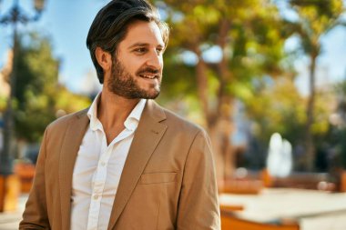 Genç İspanyol işadamı gülümseyerek şehirde mutlu mesut duruyor..