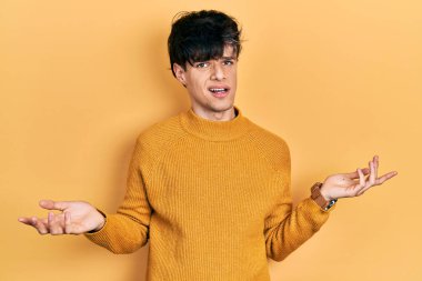 Yakışıklı hippi genç adam gündelik sarı süveter giyiyor. Hiçbir şeyden habersiz ve kolları açık, hiçbir fikri yok.. 