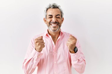 Orta yaşlı İspanyol bir adam tecrit edilmiş arka planda duruyor. Kolları havada ve gözleri kapalı zaferi kutlarken heyecanla bekliyor. Kazanan konsept. 