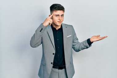 Kulakları genişlemiş, iş ceketi giymiş, açık avuç içiyle fotokopi çeken ve alnını işaret eden beyaz bir çocuk. Bunu bir düşün.. 