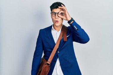 İş kıyafetleri giyen genç İspanyol adam şaşırmış yüz ifadesiyle şok olmuş, parmaklarından bakan gözler. İnançsız ifade. 