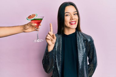 Seksi parti ceketi giymiş genç bir kız ve İspanyol kolu bir fikir ya da soruyla gülümseyen bir kokteyl sunuyor. 