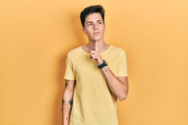 Latin asıllı genç bir adam günlük sarı tişört giyiyordu. Kuşku üzerine yoğunlaşmıştı. Parmakları çenesinde ve yukarı bakıyordu. 