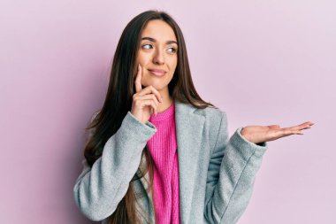 Avuç içleri açık, gülümseyen bir şey tutan, yan bakan ve düşünen İspanyol bir kız.. 