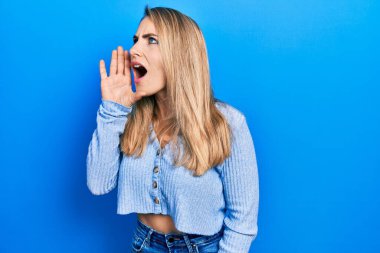 Gündelik kıyafetler giymiş genç beyaz bir kadın el ve ağızla bağırıyor ve çığlık atıyordu. iletişim konsepti. 