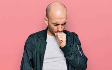 Günlük kıyafetler giyen genç İspanyol adam kendini iyi hissetmiyor ve soğuk algınlığı veya bronşitin belirtisi olarak öksürüyor. sağlık hizmeti kavramı. 