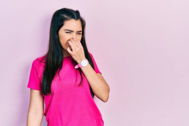 Gündelik pembe tişört giyen genç İspanyol kız pis ve iğrenç bir koku alıyor. Nefesini burnunda tutuyor. Kötü kokuyor. 