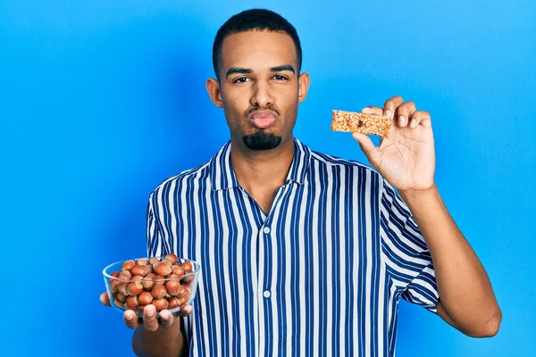 Joven Afroamericano Hombre Sosteniendo Avellanas Crudas Barra Cereales Mirando Cámara — Foto de Stock