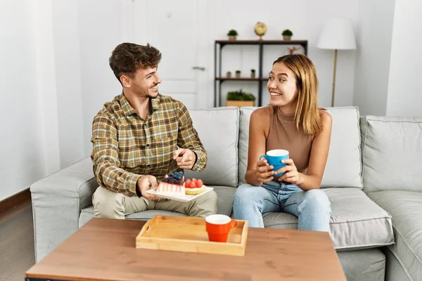 Jovem Casal Hispânico Sorrindo Feliz Tomando Café Manhã Sentado Sofá — Fotografia de Stock