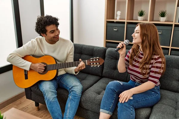 Casal Jovem Tocando Guitarra Clássica Cantando Usando Microfone Casa — Fotografia de Stock