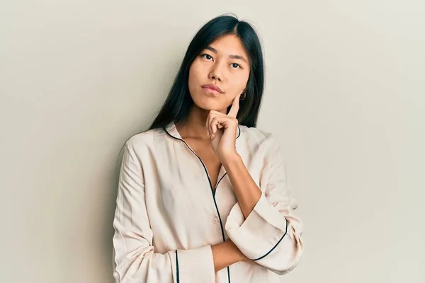 Young Chinese Woman Wearing Pajama Serious Face Thinking Question Hand — Stock Photo, Image